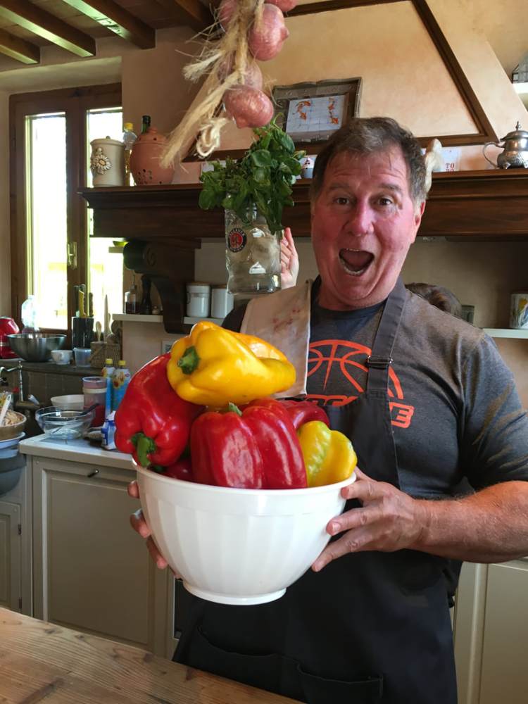 man holding a bowl of very large peppers